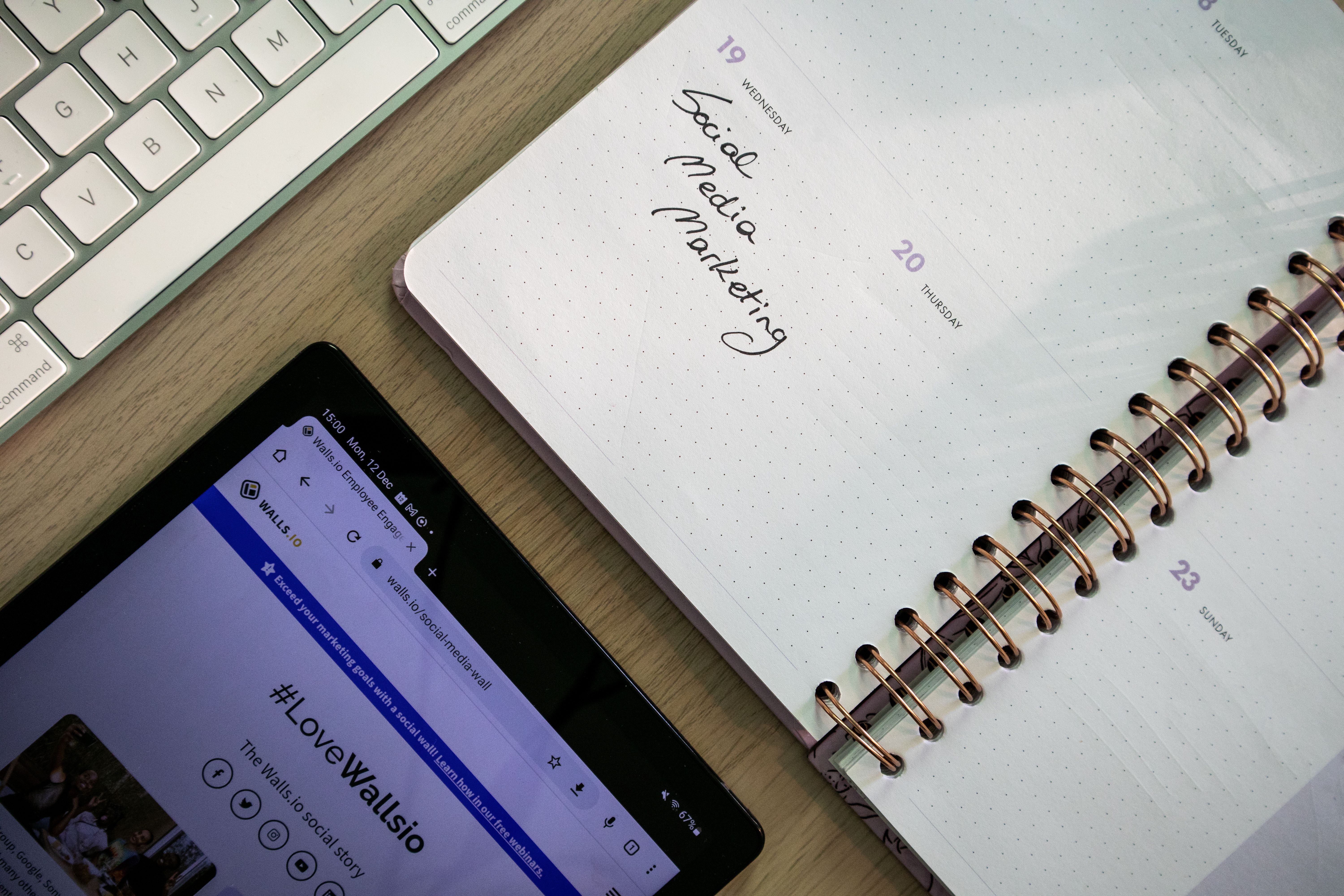 Notebook, tablet, and keyboard arranged for social media content planning