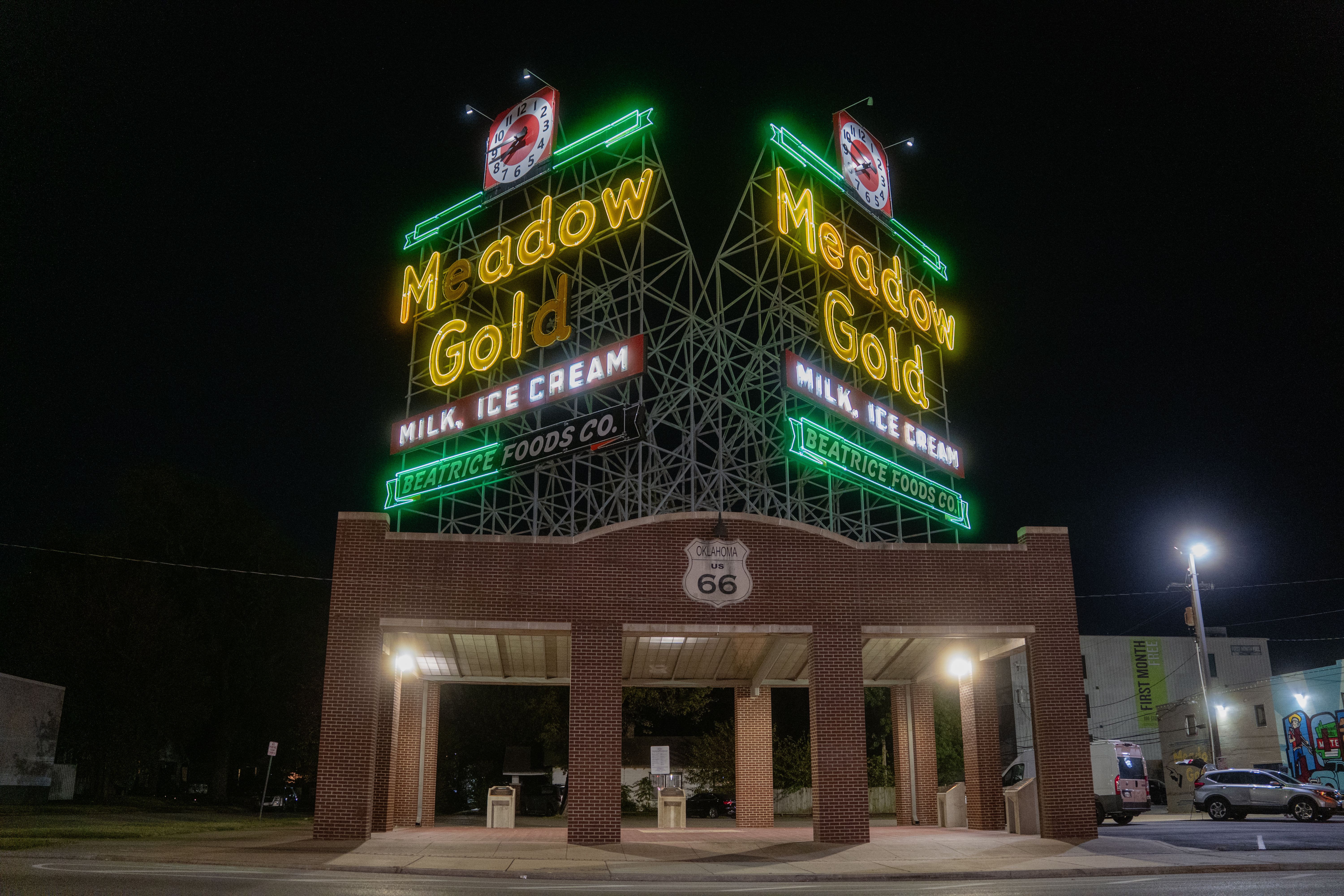Historic Meadow Gold Route 66 sign glowing at night in Tulsa